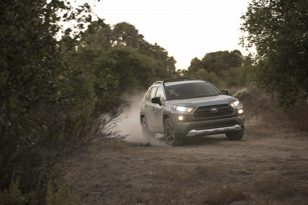 frontal view of the 2021 Toyota RAV4 as it rounds a corner on a dirt road