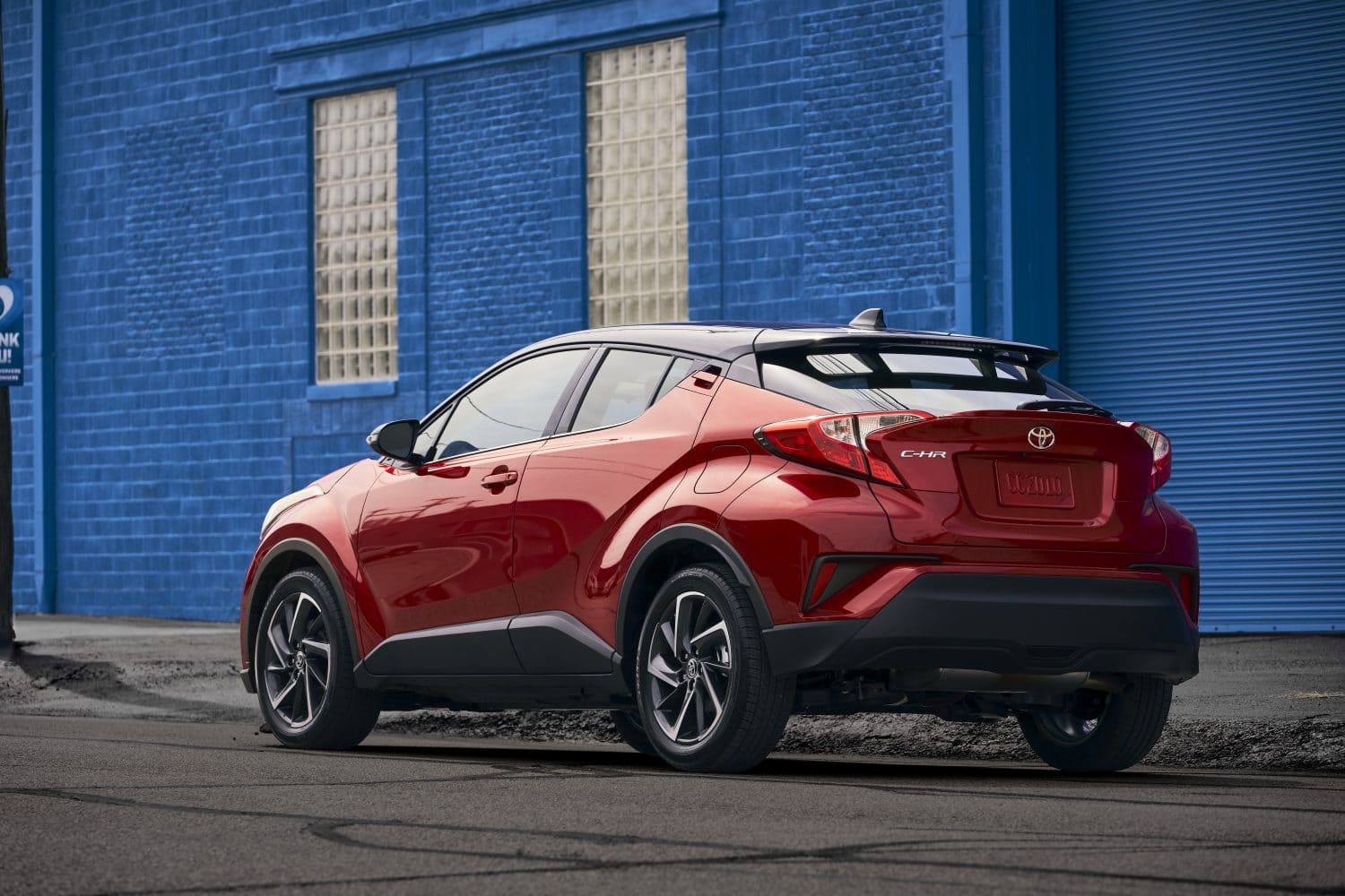 lateral side view of a 2022 Toyota C-HR 2022 in front of a blue wall