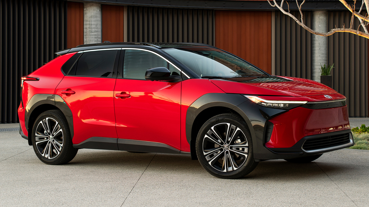 Vue latérale du Toyota BZ4x dans un stationnement publique, les phares allumés et prêt à partir