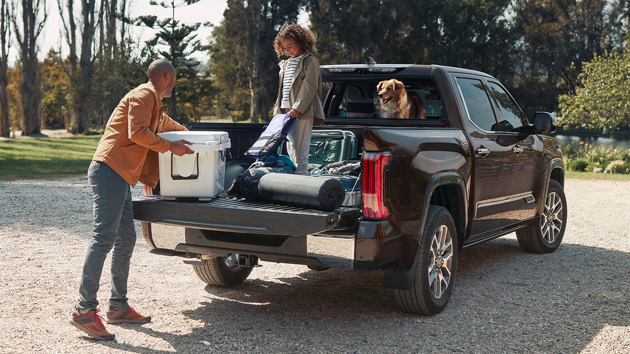 Vue arrière du Toyota Tundra 2024 avec portière arrière ouverte et une famille débarquant équipement pour la pêche