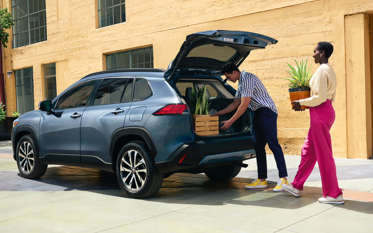 Un couple chargeant le coffre du Toyota Corolla Cross 2024.