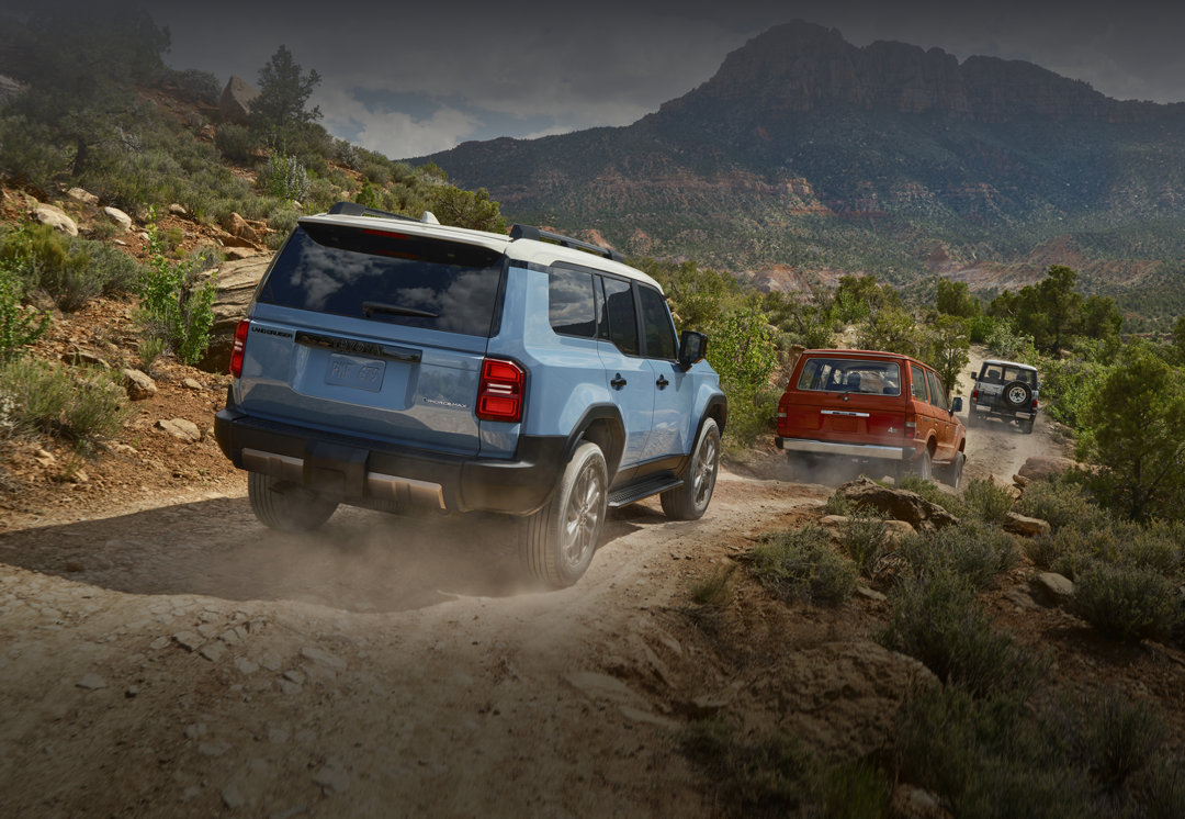 3 Toyota Land Cruiser qui se suivent sur un chemin de montagne.